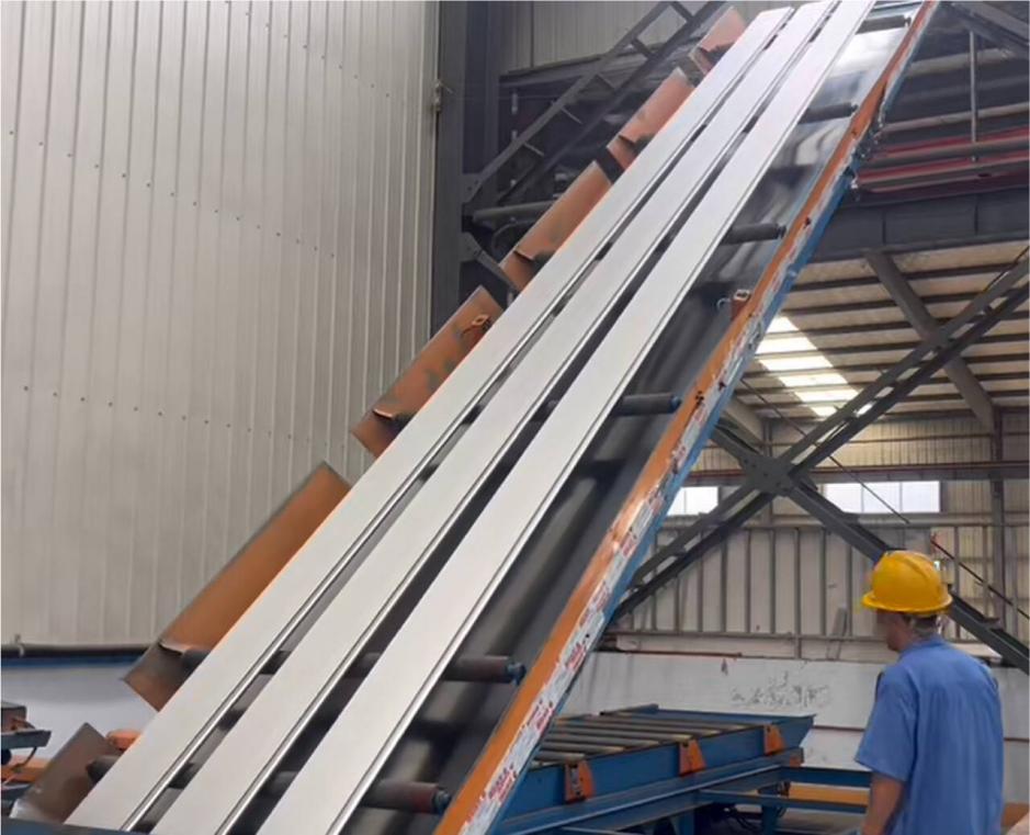 Aluminum profiles moving through a sandblasting line